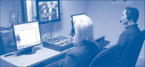 Fig. 1 – Voicewriters providing live closed captioning in a soundproof booth.